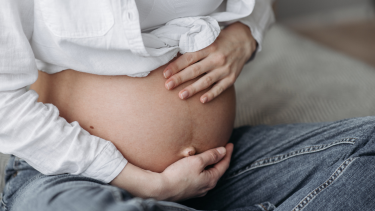Photo of pregnant woman with hands over belly